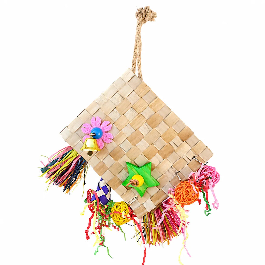 Colorful woven hanging parrot toy with natural palm leaf mat, tassels, bell, and chewable enrichment accessories on a white background.