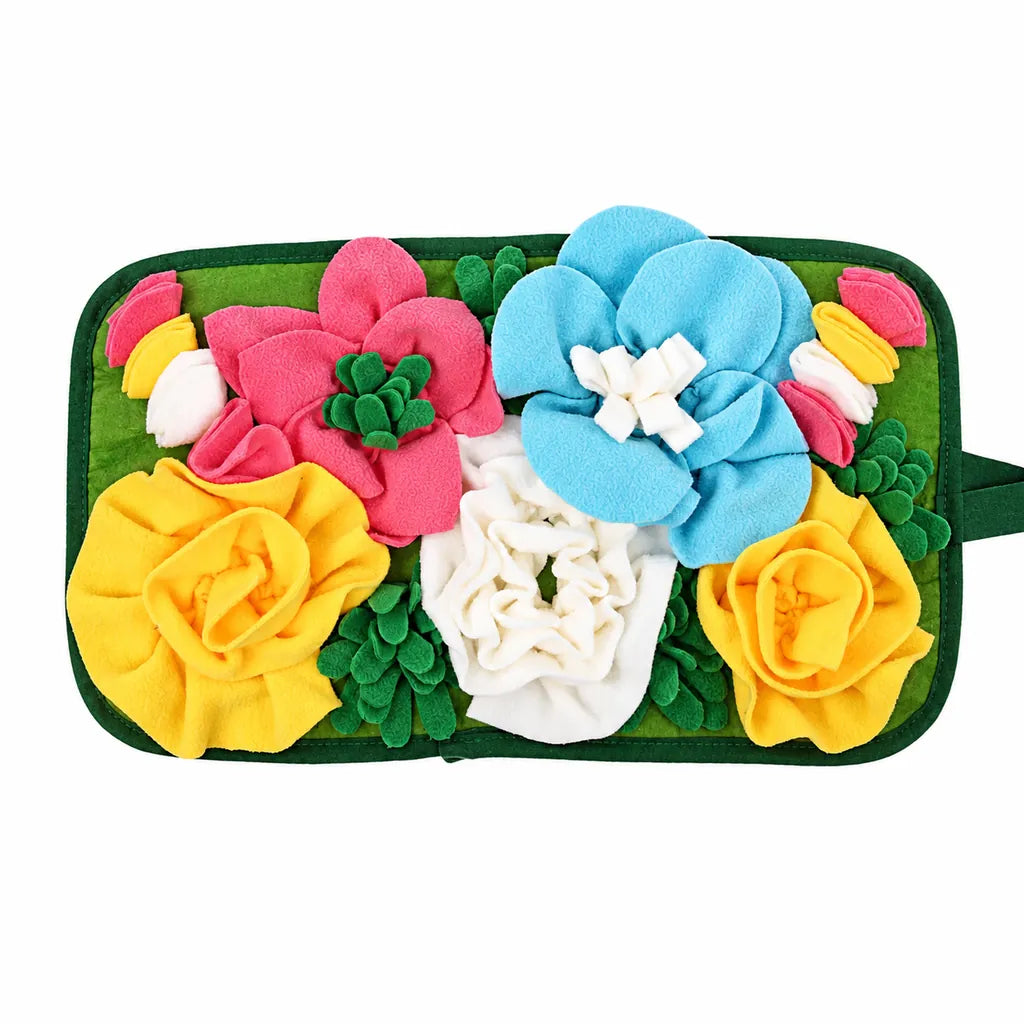 Colorful flower fleece snuffle mat for dogs and small pets with pink, blue, yellow, and white flowers on a green base, shown on a white background.