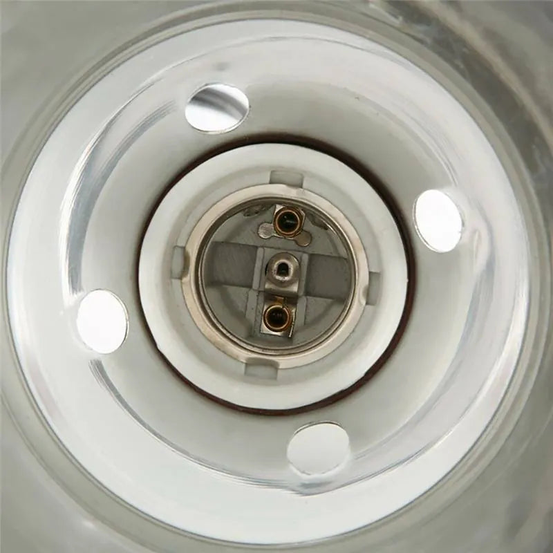 Close-up of a circular transparent container or vessel showing a metallic inner component with circular cutouts and a central threaded opening.