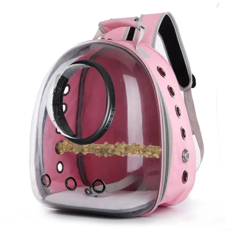 Pink transparent pet carrier backpack with clear bubble front, ventilation holes, and internal perch for transporting birds and small pets.
